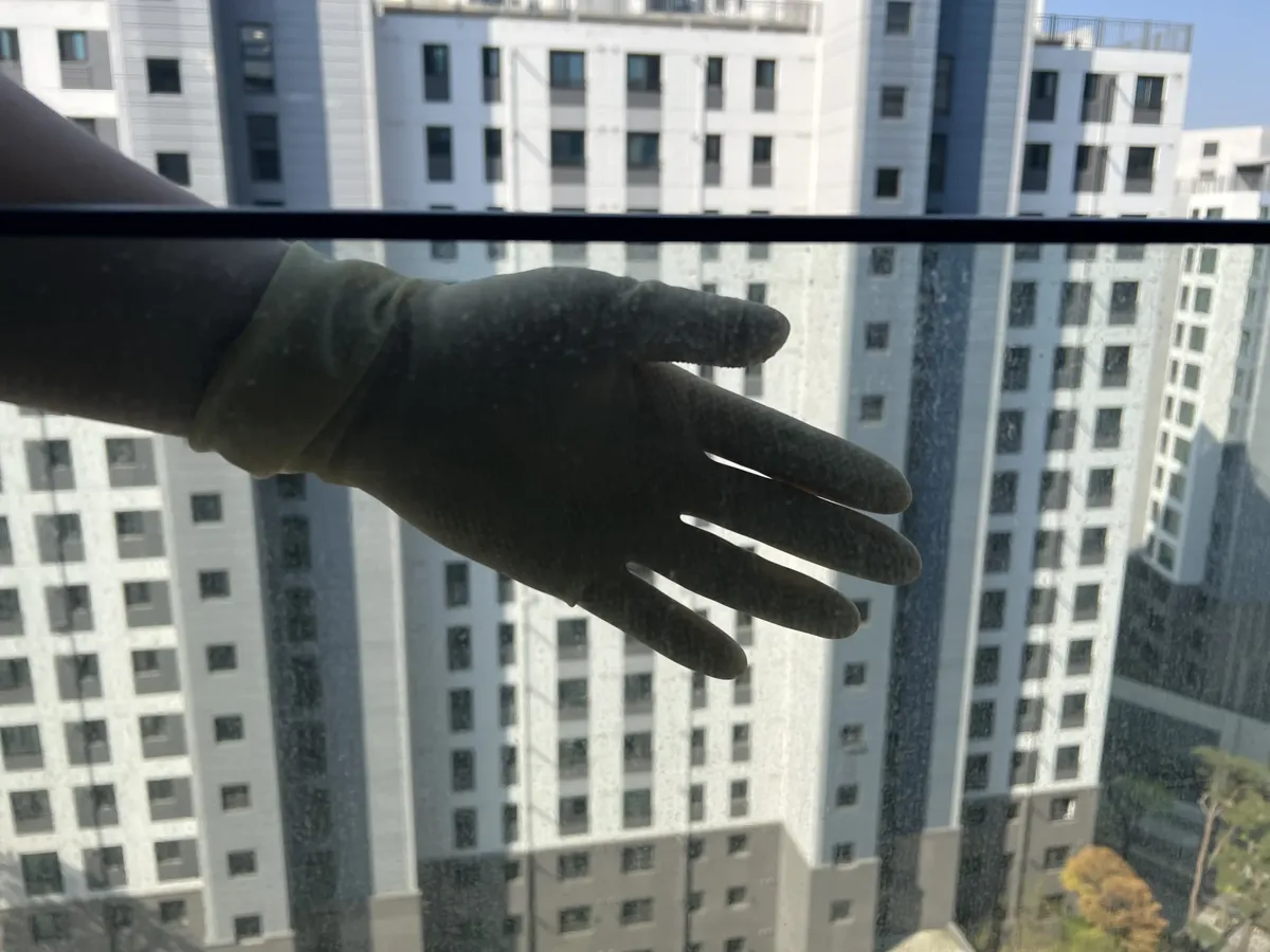 유리창얼룩제거 거실 창 작업전 장갑 너머로 보이는 유리 점 자국