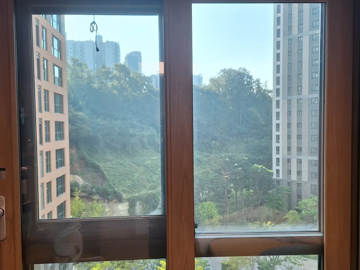 동대문유리창청소 우드톤 프레임 창 작업전 손잡이와 창틀이 보이는 창 전체