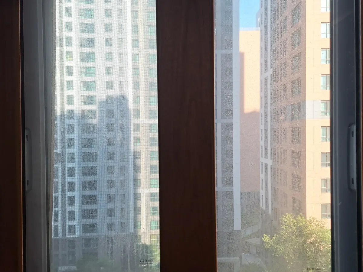 광명유리창청소 우드톤 프레임 창 작업전 두 손잡이가 보이는 창 전체