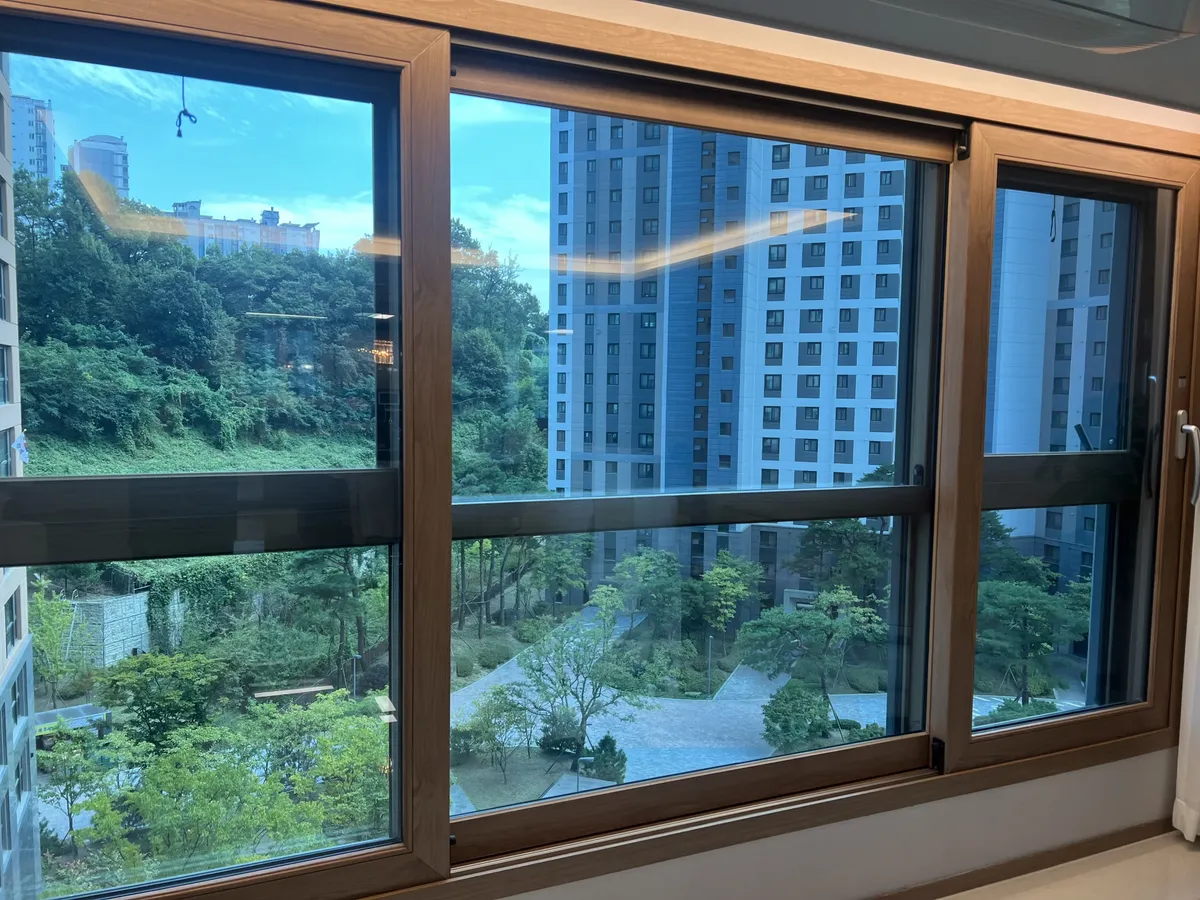 용인유리창청소 우드톤 프레임 창 작업후 푸른 하늘이 선명하게 보이는 넓은 창